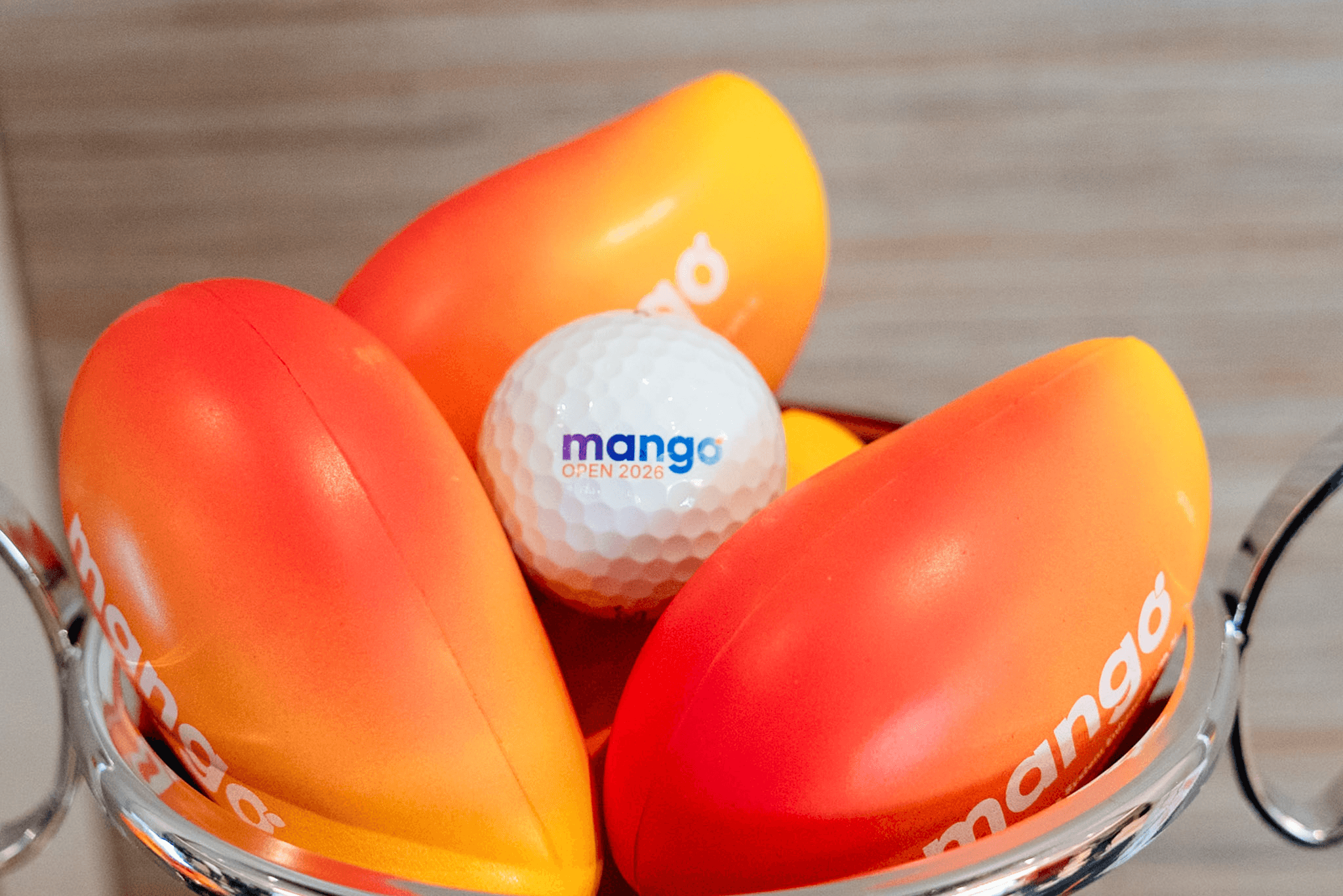 Mango-branded stress balls and a Mango Open 2026 golf ball in a bowl