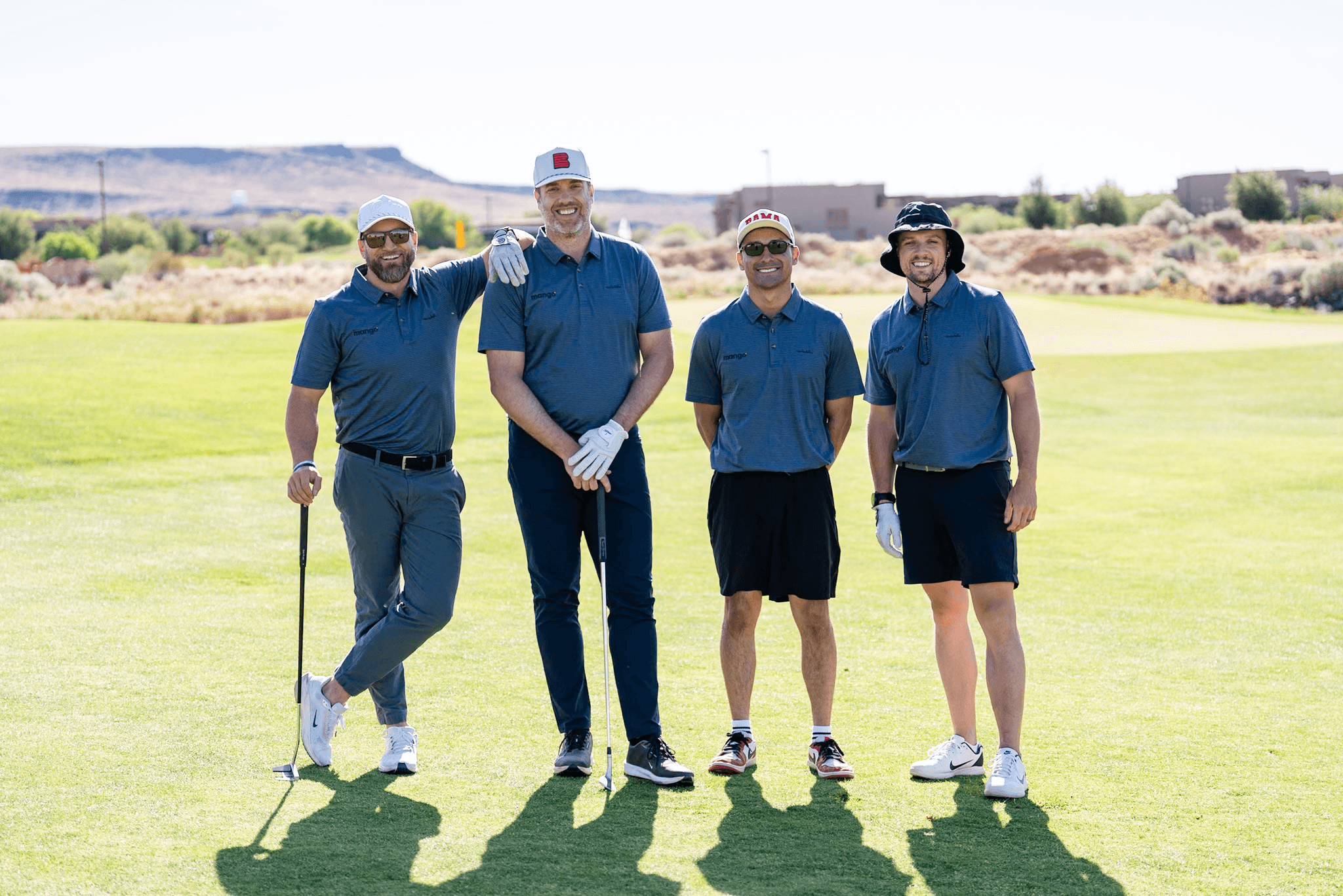 Four golfers in blue Mango polos posing on the fairway