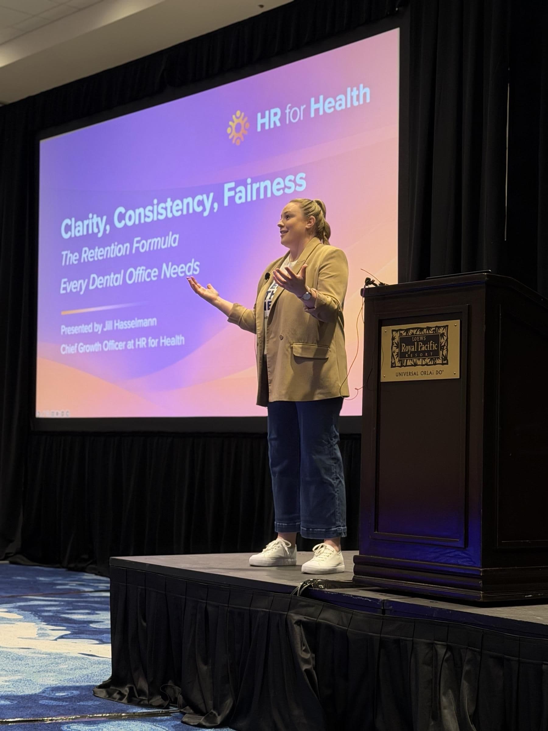 Jill Hasselmann, Chief Growth Officer at HR for Health, presenting Clarity, Consistency, Fairness on stage