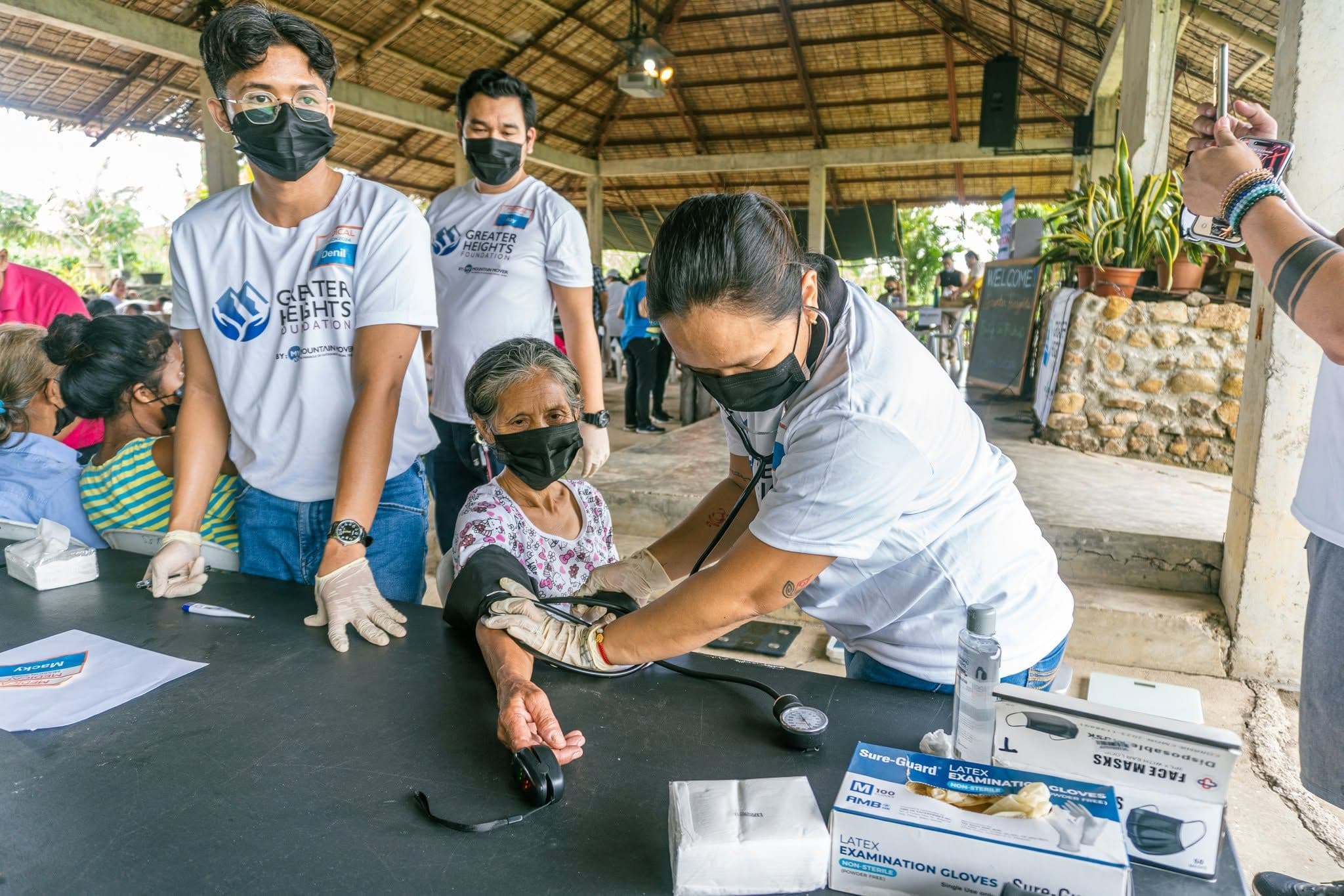 A Greater Heights Foundation volunteer checking a patient's blood pressure at the 2024 medical mission